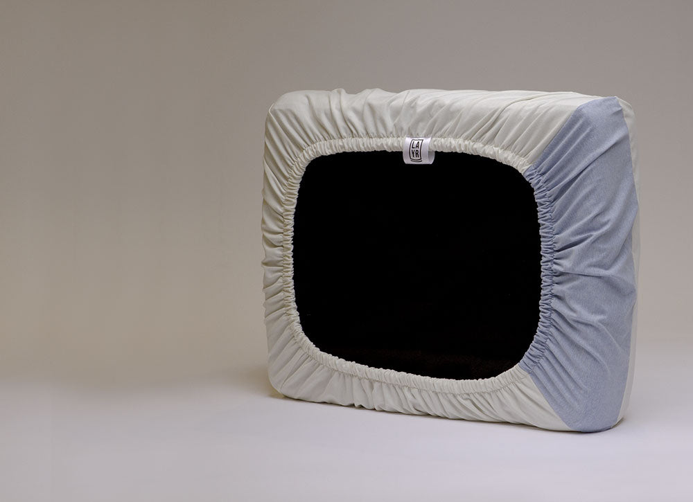 Dog bed with elastic protective cover, machine washable.