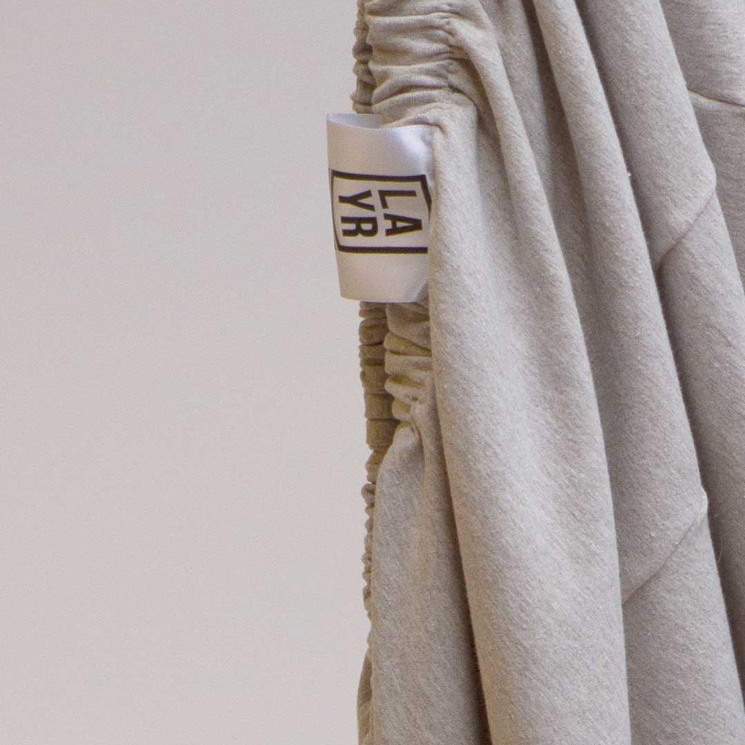 Machine washable brown sustainable dog bed cover with LAYR logo tag.