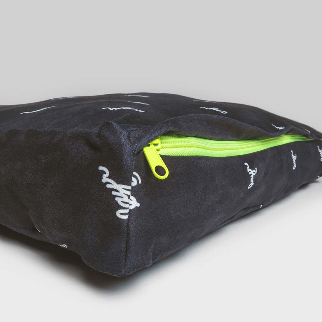 Black waterproof microsuede dog bed with LAYR logos and neon zipper.